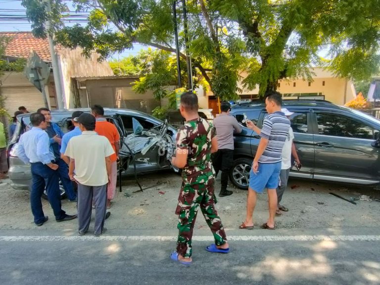 Warga melihat dua mobil yang disasak dumptruk di Jalan Raya Daendles Desa Asempapak, Kecamatan Sidayu, Gresik. (Foto: Ist/Infogresik)