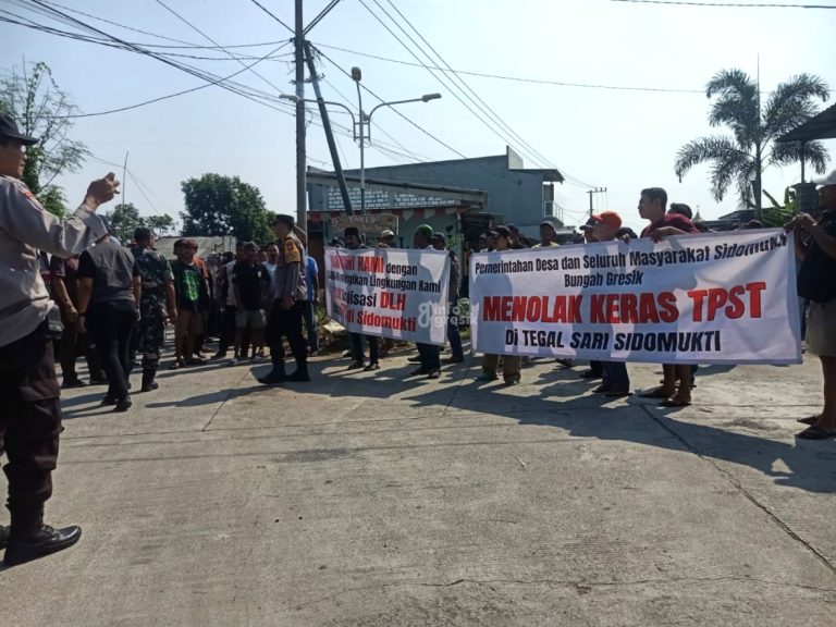 Warga Desa Sidomukti Kecamatan Bungah membentangkan spanduk penolakan pembangunan TPST. (Foto: Ist/Infogresik)