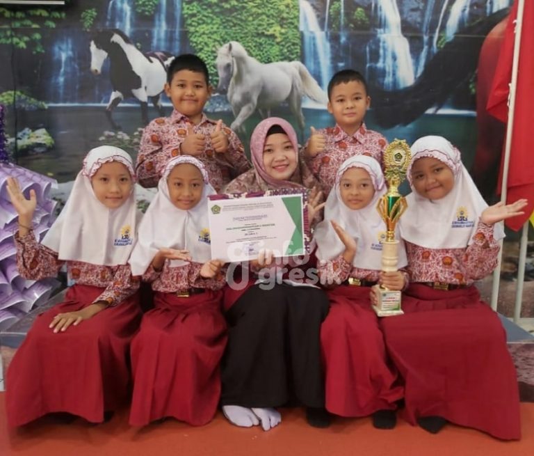 Kepala Mimdaka, Tineke Wulandari bersama para siswa menunjukan piagam penghargaan sebagai Juara 1 Lomba Lomba Madrasah Mandiri Berprestasi dari Kemenag Gresik. (Foto: Istimewa/Infogresik)