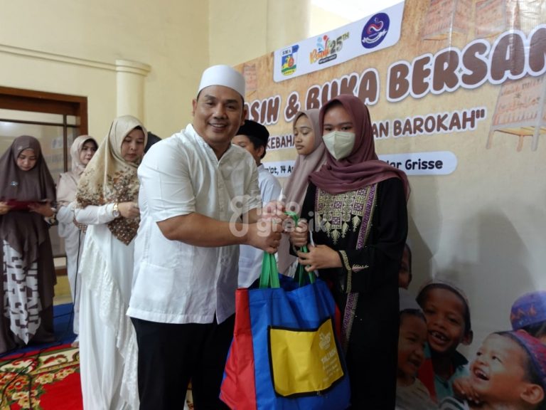 Koordinator Smansa Gresik angkatan 98, Machmud Kholil saat menyerahkan santunan dan bingkisan untuk anak yatim. (Foto: Khanif Rosidin/Infogresik)