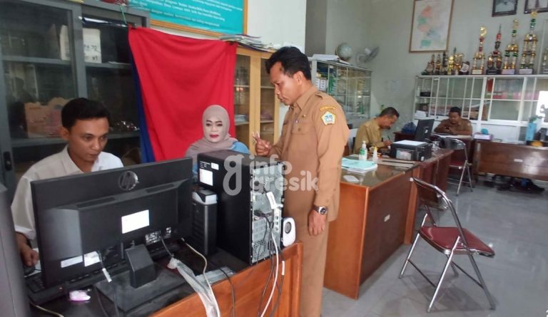 Kades Lowayu Amin Iskandar (kanan) mendampingi warga membuat KTP di balai desa. (Foto: Ist/Infogresik)