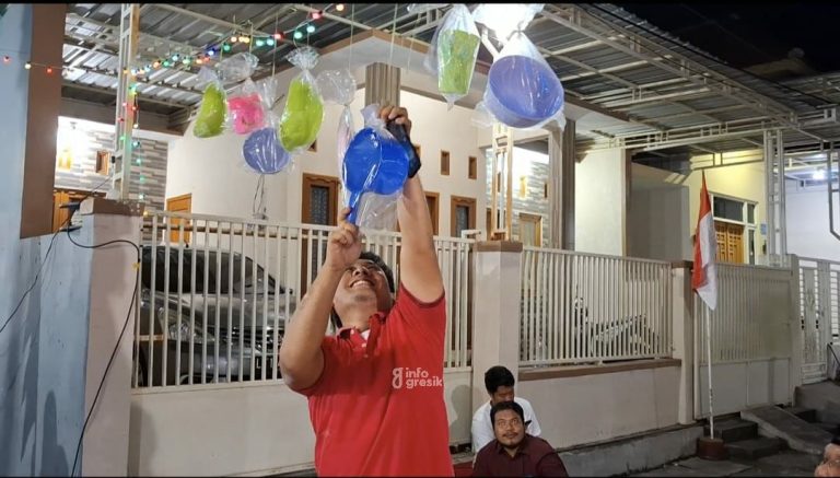 Salah satu warga RT 05 RW 06 Perumahan Graha Bunder Asri (GBA) Desa Kembangan saat mengambil hadiah. (Foto: Ist/Infogresik)