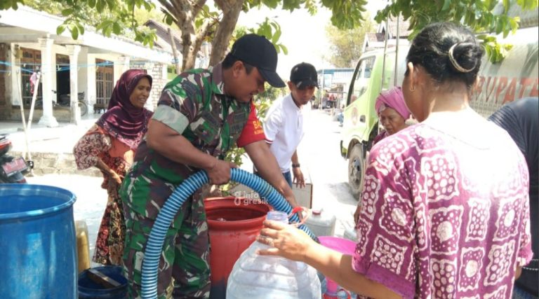 Petugas Babinsa Koramil Balongpanggang saat membantu menyalurkan air bersih untuk warga Desa Tenggor. (Foto: Ist/Infogresik)