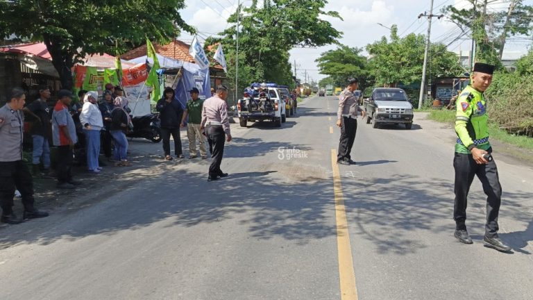 Petugas polisi saat olah TKP di lokasi tabrakan sepeda motor dengan truk di Jalan Bringkang Menganti. (Foto: Ist/Infogresik)