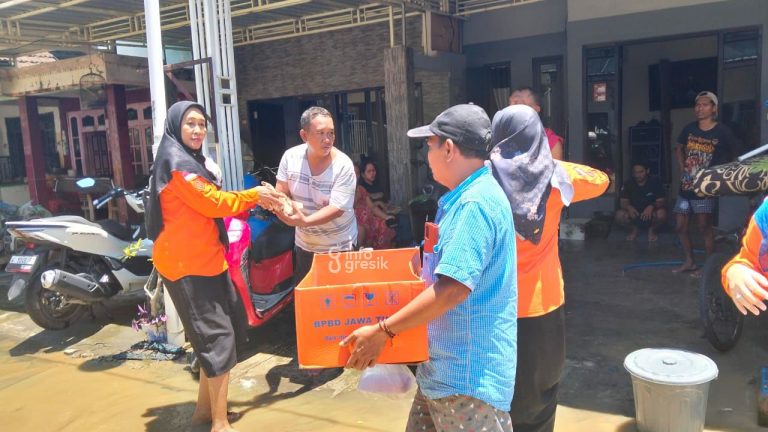 Bangun Dapur Umum, Pemkab Gresik Bagikan Nasi Bungkus untuk Korban Banjir Tim BPBD Gresik saat membagikan nasi bungkus untuk warga terdampak banjir di Desa Sekarputih, Kecamayan Balongpanggang. (Foto: Ist/Infogresik)