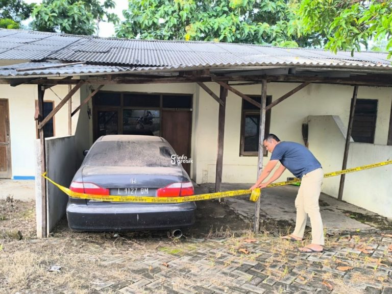 Petugas Polisi saat memasang garis polisi di mobil milik mantan Kanit Reskrim Polsek Ujungpangkah. (Foto: Ist/Infogresik)