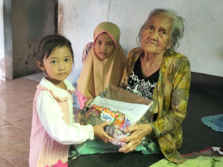 Belajar Kepedulian Sejak Dini, Siswa TK di Gresik Berbagi Bingkisan Lebaran untuk Warga Salah satu siswa, Naura Azmi, saat menyerahkan bantuan bingkisan untuk warga di Desa Karangrejo, Ujungpangkah. (Foto: Ist/Infogresik)