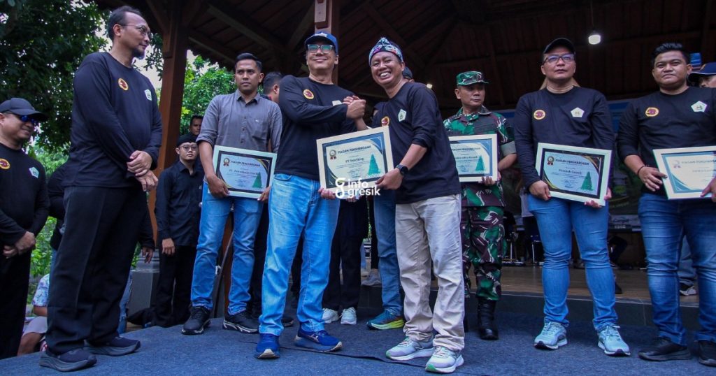 Ketua Panitia Festival Nasi Krawu, Khanif Rosidin, saat menyerahkan penghargaan kepada Section Manager General Affairs PT Smelting, Indra SW Junor. (Foto: Ist/Infogresik)