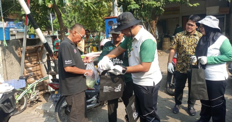Kurangi Sampah, DLH dan Petrokimia Gresik Bagi-bagi Tote Bag di Pasar Tradisional  VP Lingkungan Hidup Petrokimia Gresik, Bagus Eka Saputra, bersama tim DLH Gresik saat membagikan tote bag ke pengunjung pasar. (Foto: Khanif Rosidin/Infogresik)