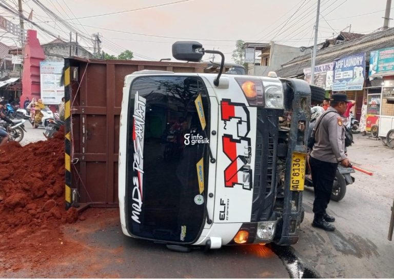 Kondisi dumptruk bermuatan tanah merah yang terbalik dan menutup separuh badan jalan di Desa Sembayat, Kecamatan Manyar. (Foto: Ist/Infogresik)