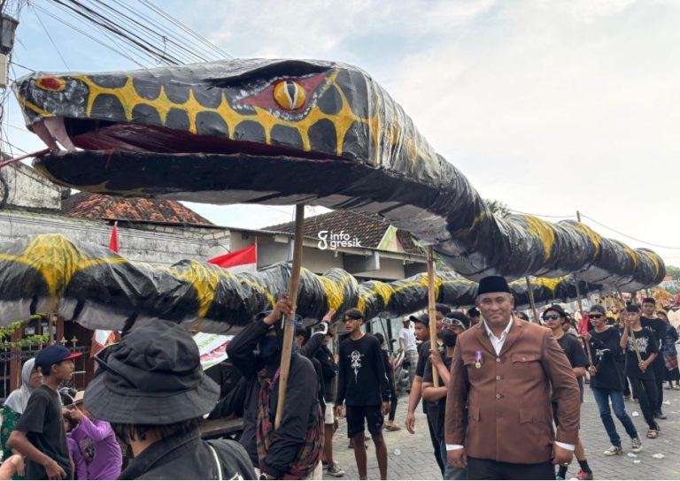 Kepala Desa Pangkahwetan, Syaifullah Mahdi, melihat salah satu peserta yang membawa replika ular Bengawan Solo sepanjang 50 meter. (Foto: Khanif Rosidin/INFOGRESIK)