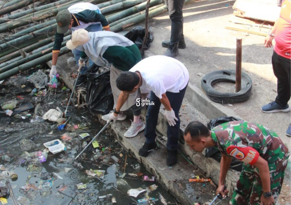 Kepala DLH Gresik, Sri Subaidah, bersama Plt Kadiskominfo, Johar Gunawan, anggota TNI, serta masyarakat saat membersihkan sampah di Pantai Kelurahan Lumpur, Gresik. (Foto: Ist/INFOGRESIK)