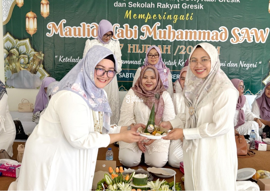 Ketua GOW Gresik, dr. Shinta Puspitasari, menyerahkan tumpeng secara simbolis kepada istri Dandim Gresik, Yuristi Fadly Karamaha, sebagai tanda dimulainya acara makan bersama. (Foto: Khanif Rosidin/Infogresik)