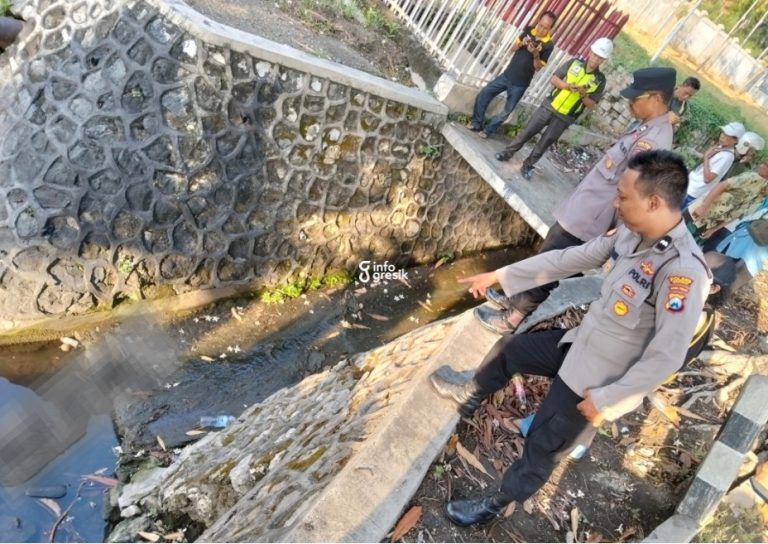 Petugas Polsek Kebomas menunjukkan lokasi ditemukannya korban. (Foto: Ist/InfoGresik)