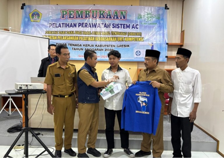 Kepala Dinas Ketenagakerjaan (Disnaker) Gresik, Zainul Arifin, menyerahkan modul belajar dan kaos kepada salah satu peserta, didampingi Wakil Ketua PCNU Gresik, Syifaul Qulub, dan Ketua LPK Omah Masyarakat Berdaya Gresik, M. Hisyam. (Foto: Khanif Rosidin/Infogresik)