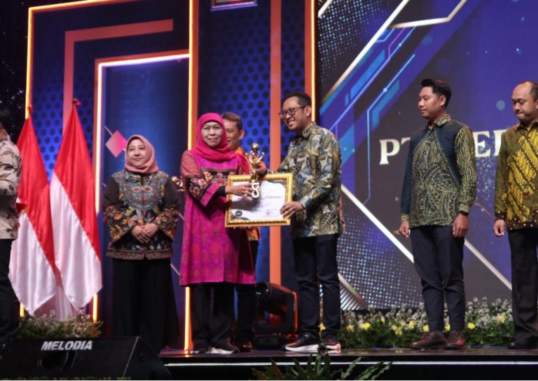 Gubernur Jatim, Khofifah Indar Parawansa, saat menyerahkan penghargaan kepada manajemen JIIPE yang diwakili Direktur Keuangan PT BKMS, Ifan Johar Kuswahyudi. (Foto: Ist/INFOGRESIK)