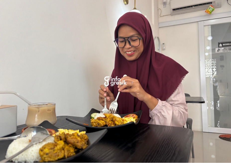 Salah satu pengunjung Orange 2 Laundry, Barber & Cafe menikmati hidangan ayam taliwang sembari menunggu cucian selesai. (Foto: Khanif Rosidin/Infogresik)