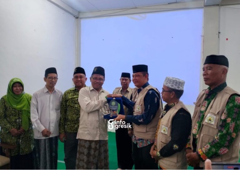 Ketua PD DMI Kabupaten Gresik, KH. Zainal Abidin, saat menyerahkan cinderamata kepada perwakilan DMI Sukamara. (Foto: Ist/Infogresik)
