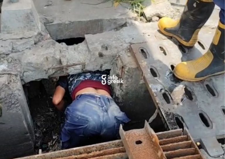 Personel Damkarla Gresik saat masuk ke dalam gorong-gorong demi mengambil dompet milik warga. (Foto: Ist/Infogresik)