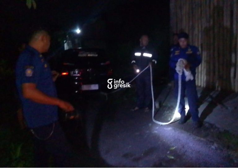 Petugas Damkarla Pos Driyorejo membantu proses evakuasi sebuah mobil yang terperosok. (Foto: Ist/Infogresik)