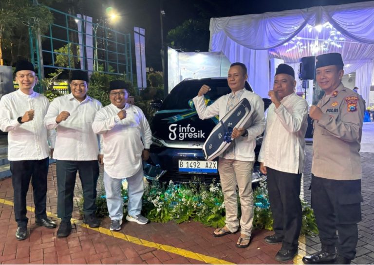 Pemenang undian, Subeni, didampingi Manager PLN UP3 Gresik, Suhandopo, serta para tamu undangan berfoto bersama mobil listrik hadiah dari PLN. (Foto: Khanif Rosidin/Infogresik)