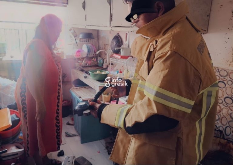 Petugas Damkarla Gresik saat melakukan pengecekan pada regulator dan selang LPG yang diduga menjadi penyebab ledakan di Kebomas. (Foto: Ist/Infogresik)
