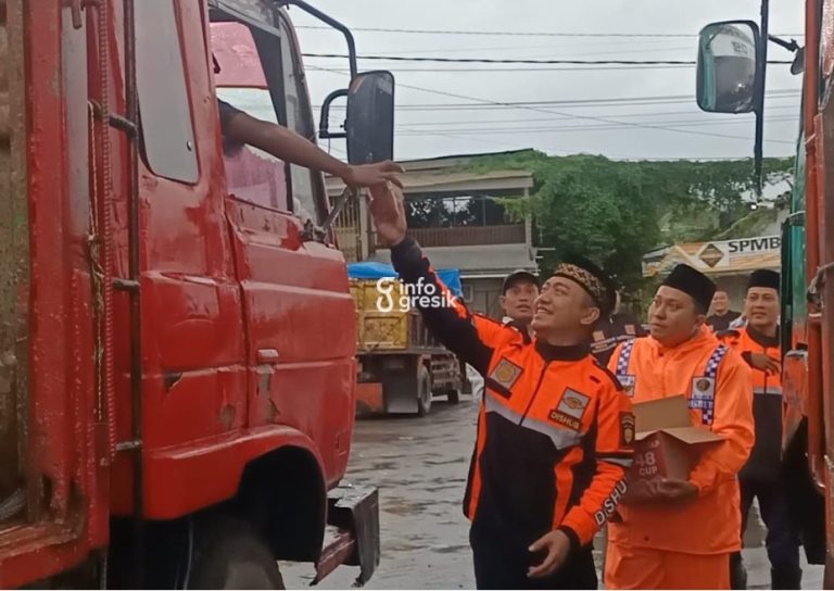 Kepala UPT Pengelolaan Prasarana Perhubungan Wilayah Kota Dishub Gresik, Muhammad Masyhur Arif, bersama petugas Dishub saat membagikan takjil kepada sopir truk di TPK Ngawen, Sidayu. (Foto: Ist/Infogresik)