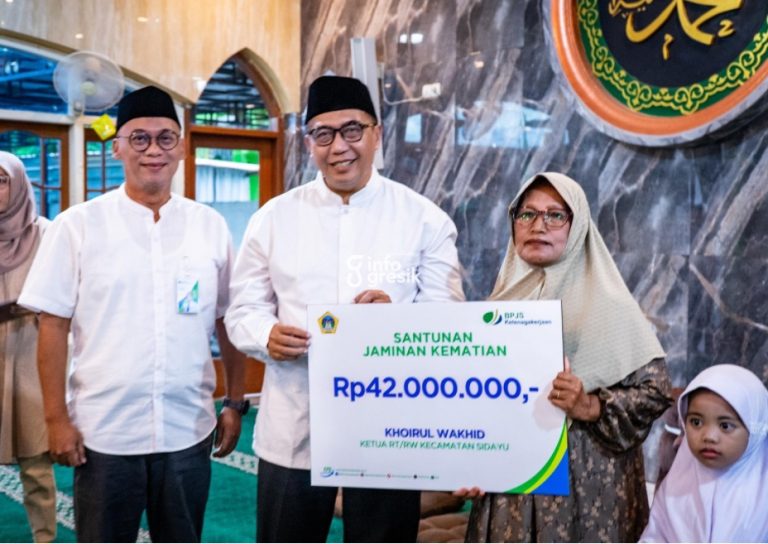 Sekretaris Daerah (Sekda) Gresik, Achmad Washil, didampingi Kepala Kantor Cabang BPJS Ketenagakerjaan Gresik, Purwantono, saat menyerahkan santunan kepada ahli waris Ketua RT dari Kecamatan Sidayu. (Foto: Ist/Infogresik)