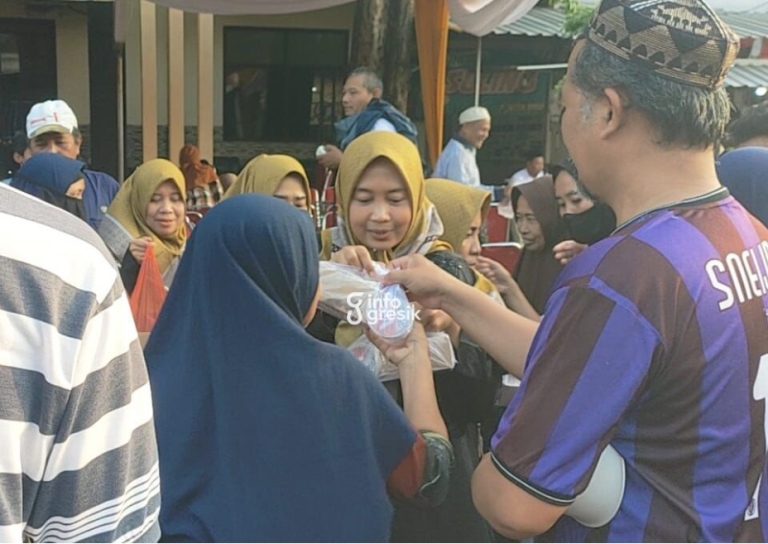 Ketua Paguyuban Istri Wartawan Komunitas Wartawan Gresik (KWG), Indah saat membagikan takjil kepada pengendara di depan Sekretariat KWG. (Foto: Ist/Infogresik)