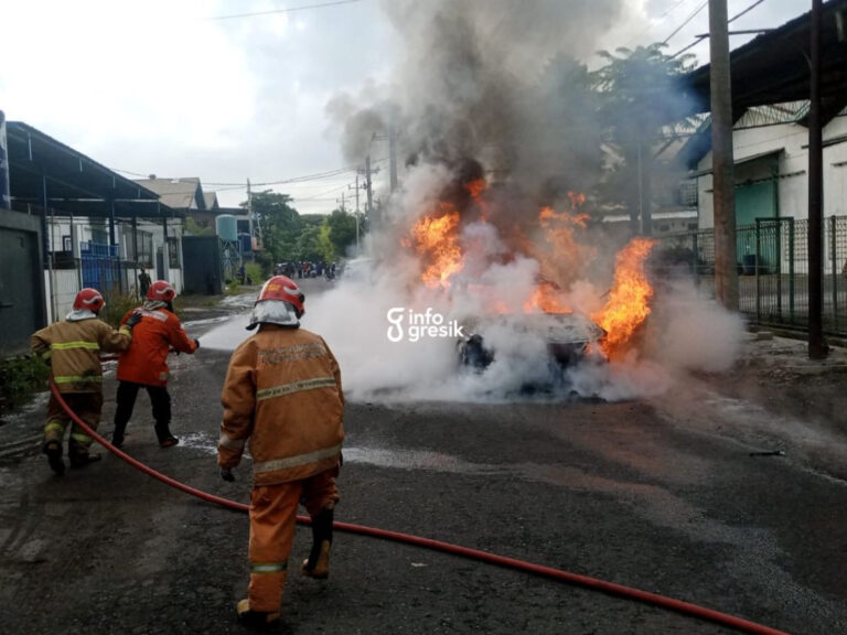 Petugas Damkarla Gresik saat melakukan pemadaman mobil listrik yang terbakar di Kebomas. (Foto: Ist/Infogresik)
