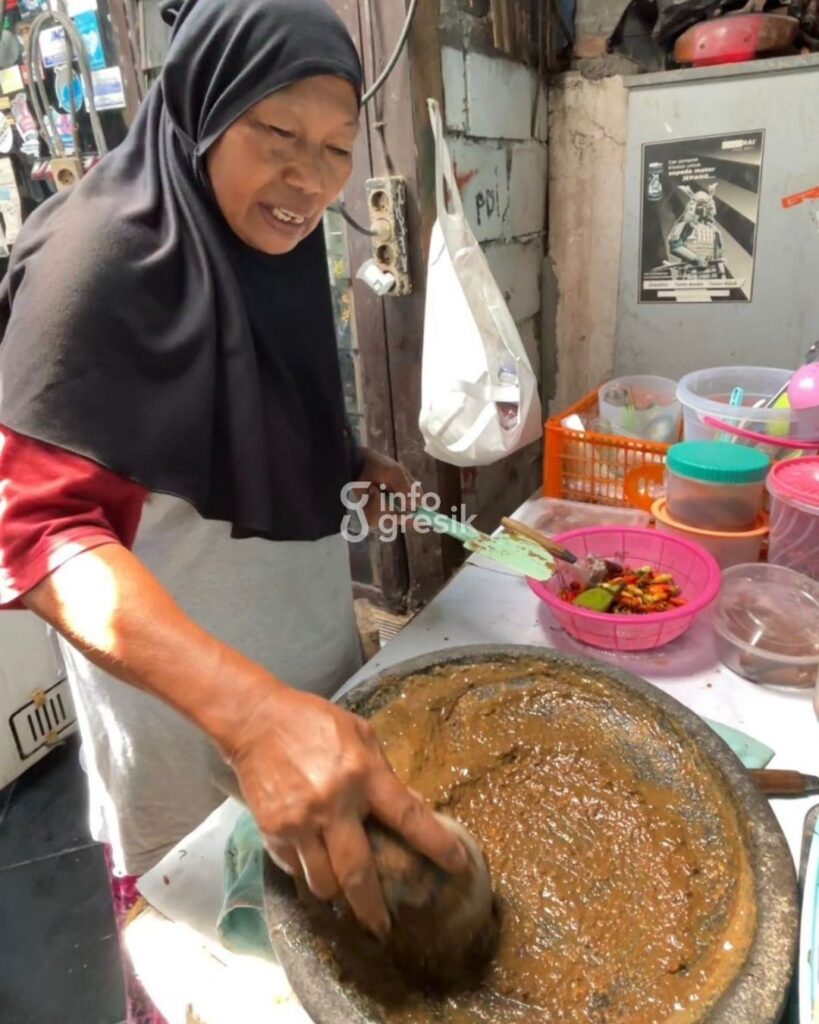 Bu Is saat meracik bumbu petis untuk rujak cingur buatannya. (Foto: Khanif Rosidin/Infogresik)