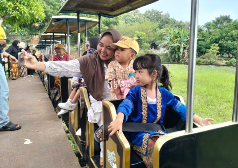 Pengunjung berkebaya menikmati perjalanan dengan kereta wisata di Wisata Alam Gosari. (Foto: Ist/Infogresik)