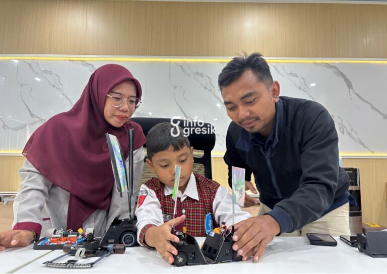 Abyan Nabil Kurniawan, siswa SD Muhammadiyah GKB 2 menunjukkan robot buatannya, didampingi pelatih robotika Rizki Kurniawan dan Waka Kesiswaan Sonya. (Foto: Khanif Rosidin/Infogresik)