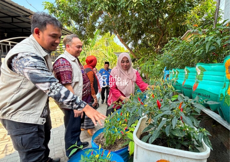 Ketua Bank Sampah Gemes Sekardadu, Siti Fitriah (kanan), menjelaskan kepada Senior Manager Keuangan, Komunikasi, dan Umum PLN UIT JBM, Andri Oktavian, mengenai tanaman yang menggunakan kompos organik hasil pengolahan sampah. (Foto: Khanif Rosidin/Infogresik)