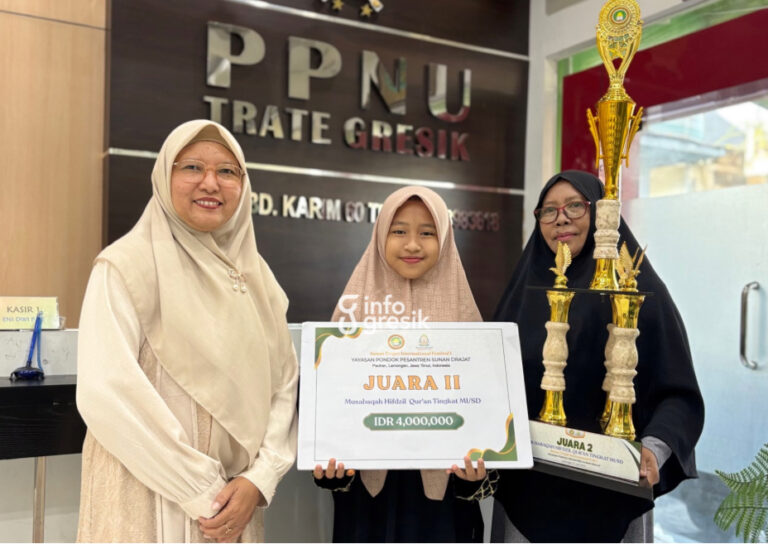 Menjaga Kalam Ilahi di Antara Magrib dan Subuh: Kisah Annisa, Siswi MINU Trate Gresik Juara MHQ Internasional Siswi MINU Trate Putri Gresik, Noor Annisa Qurrota’ Aini menunjukkan piagam dan Piala Juara II Musabaqah Hifzhil Qur’an (MHQ), didampingi sang ibu, Mafulah (kanan), serta Kepala MINU Trate Putri Gresik, Ainur Rahmah (kiri). (Foto: Khanif Rosidin/Infogresik)