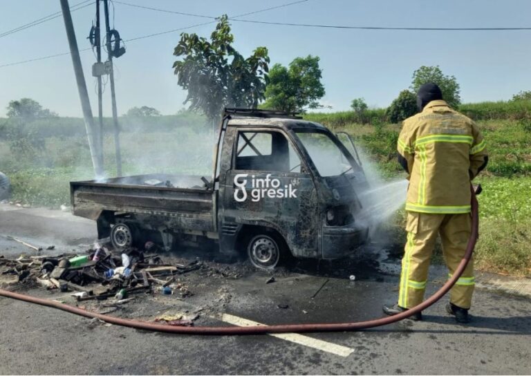 Petugas Damkarla Gresik saat memadamkan api yang membakar mobil pick up bermuatan barang bekas di area persawahan Desa Sidoraharjo, Kecamatan Kedamean, Senin (6/7/2026). (Foto: Ist/Infogresik)