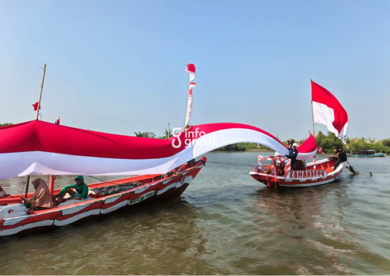 Nelayan Desa Pangkahkulon, Kecamatan Ujungpangkah, Kabupaten Gresik, membentangkan bendera Merah Putih sepanjang 45 meter di muara Sungai Bengawan Solo dalam rangka memperingati HUT ke-81 Kemerdekaan RI. (Foto: Ist/Infogresik)