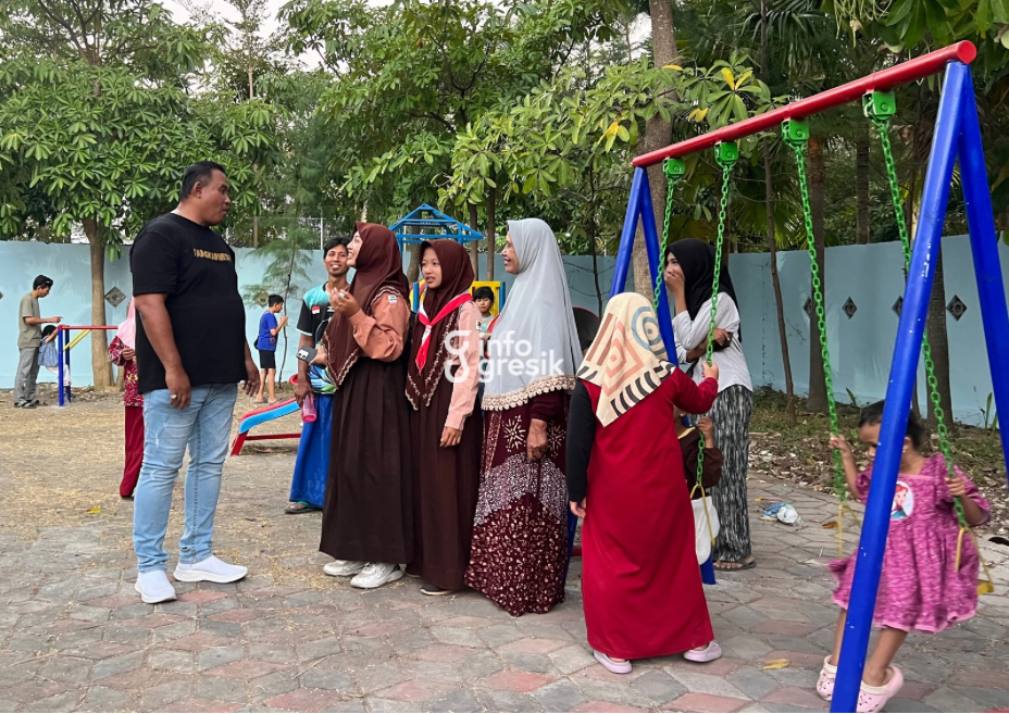 Kepala Desa Pangkahwetan Syaifullah Mahdi berbincang dengan warga yang memanfaatkan area permainan anak di RTH D’Krobyokan. (Foto: Khanif Rosidin/Infogresik)