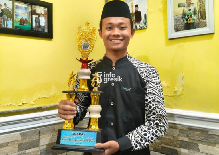 Siswa MA Kanjeng Sepuh, Mohammad Royyan Habibullah, saat menunjukkan trofi Juara 1 Cabang Tilawah Al-Qur’an Remaja Putra pada MTQ Tingkat Kabupaten Bangkalan. (Foto: Ist/Infogresik)