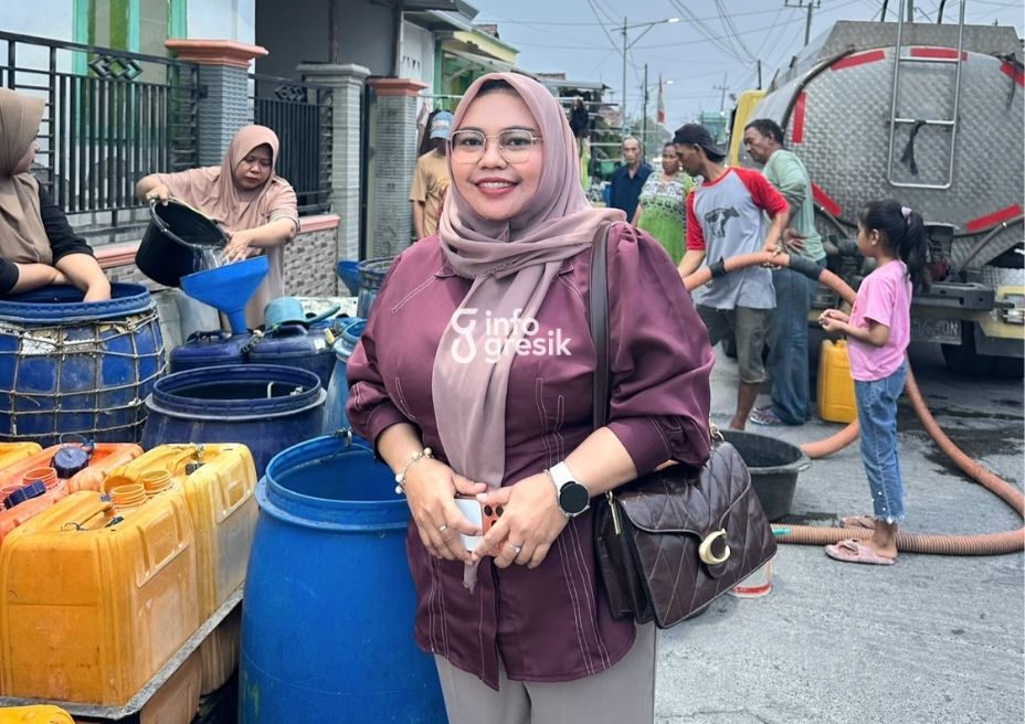 Pemilik Depot Mbok Dju, Siti Muntamah, saat menyerahkan bantuan air bersih kepada warga. (Foto: Ist/Infogresik)