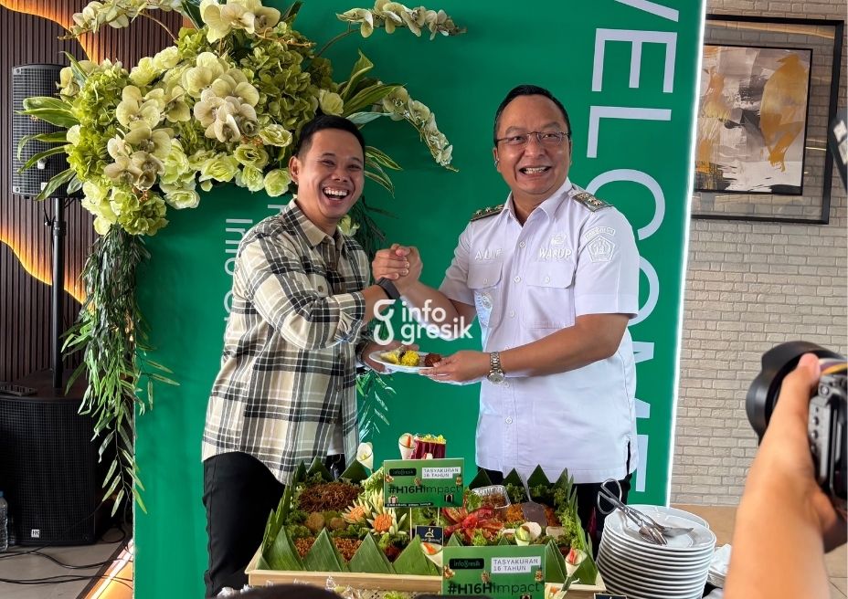 Wabup Gresik dr. Asluchul Alif menyerahkan potongan tumpeng secara simbolis kepada CEO Infogresik Muhammad Irwan dalam tasyakuran HUT ke-16 Infogresik. (Foto: Khanif Rosidin/Infogresik)